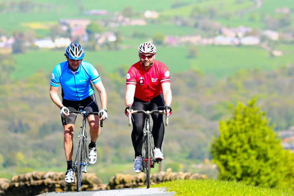 Two fat men cycling up a hill