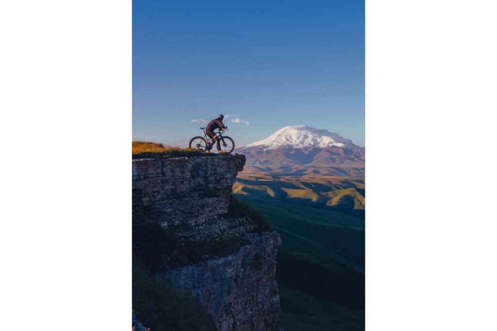 man riding bike on cliff